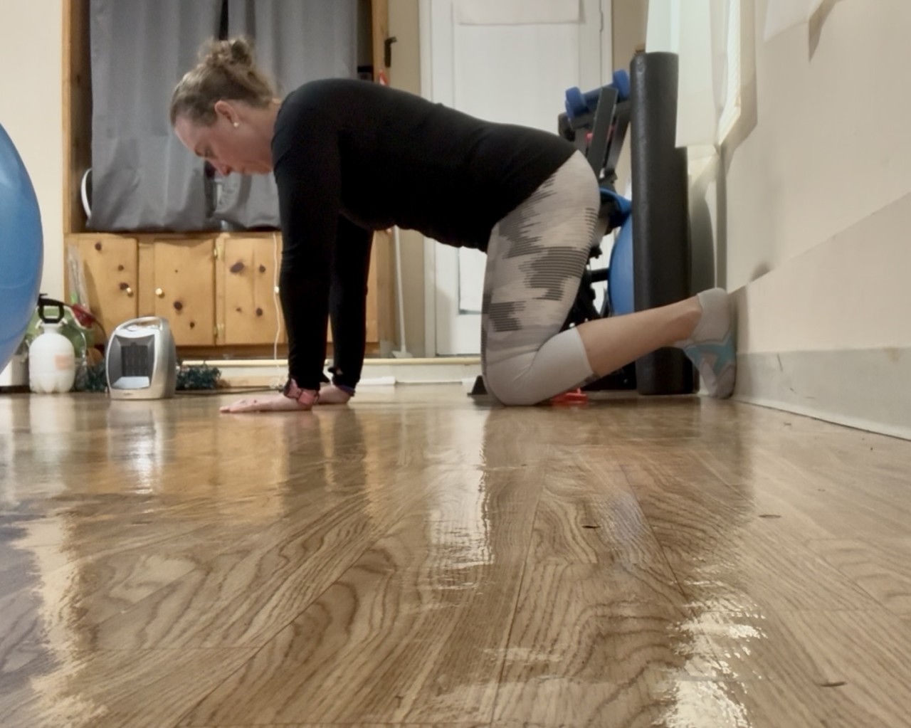 A women in a hands and kness position with her feet on a wall